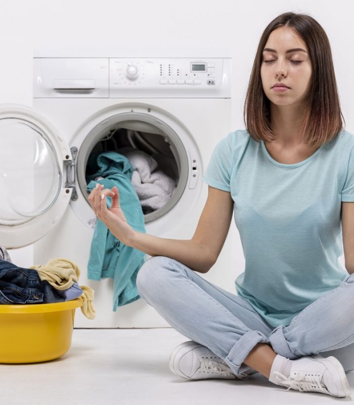 mulher-meditando-junto-a-maquina-de-lavar-imagem-cortada